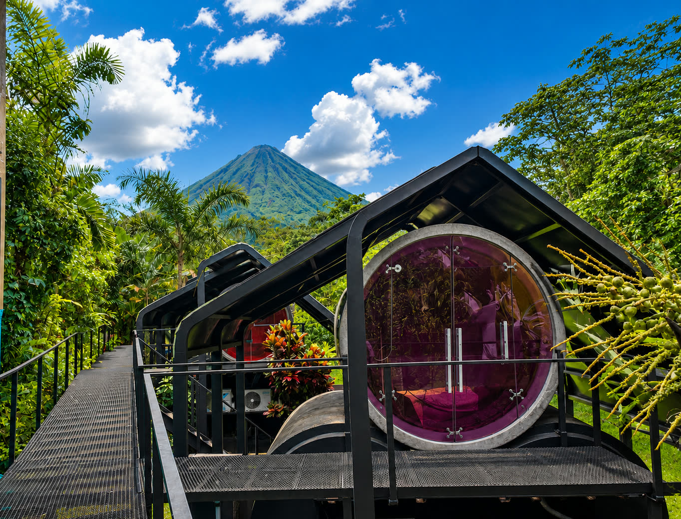 Cylinder rooms surrounded by tropical gardens with Arenal Volcano in the background